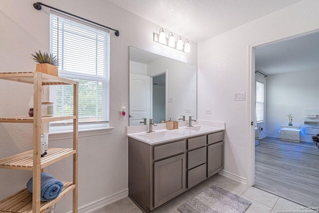 8298 Assumption Dr, San Antonio, TX 78254 - full bath featuring double vanity, tile patterned floors, and a textured wall