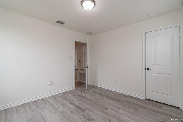 8298 Assumption Dr, San Antonio, TX 78254 - empty room featuring light wood-style flooring and a smoke detector