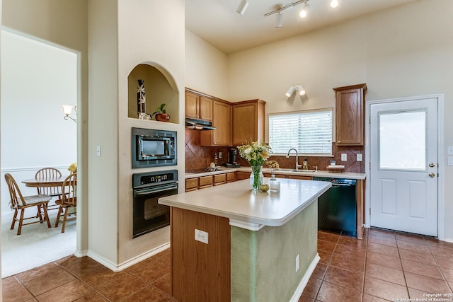 20927 Las Lomas Blvd, San Antonio, TX 78258 - kitchen with black appliances, a towering ceiling, under cabinet range hood, light countertops, and tile patterned floors