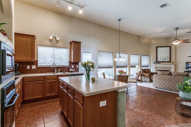 20927 Las Lomas Blvd, San Antonio, TX 78258 - kitchen with oven, open floor plan, brown cabinetry, a center island, and a high ceiling