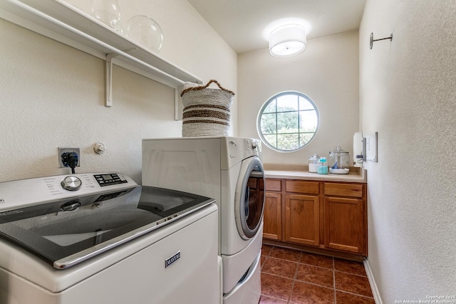 20927 Las Lomas Blvd, San Antonio, TX 78258 - laundry area featuring washing machine and clothes dryer, dark tile patterned floors, a textured wall, and cabinet space