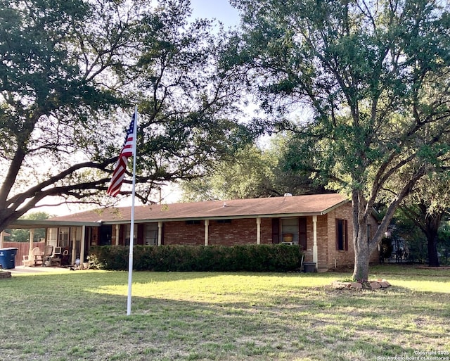 404 Alta, Pleasanton, TX 78064 - ranch-style house with a front yard and brick siding