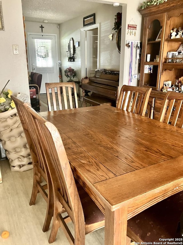 404 Alta, Pleasanton, TX 78064 - dining room with light wood-style flooring and a textured ceiling