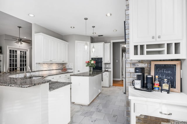 109 Trailcrest, Hollywood Park, TX 78232 - kitchen with oven, a center island, a ceiling fan, white cabinets, and backsplash