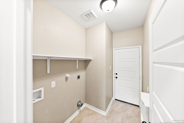 11406 Sawyer Vly, San Antonio, TX 78254 - laundry room featuring hookup for an electric dryer, a textured ceiling, washer hookup, gas dryer hookup, and light tile patterned floors