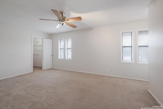 6403 Port Royal, San Antonio, TX 78244 - unfurnished bedroom with light colored carpet, a textured ceiling, a spacious closet, ceiling fan, and a closet