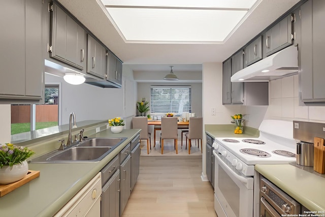 6403 Port Royal, San Antonio, TX 78244 - kitchen with under cabinet range hood, white appliances, light wood-style flooring, tasteful backsplash, and light countertops
