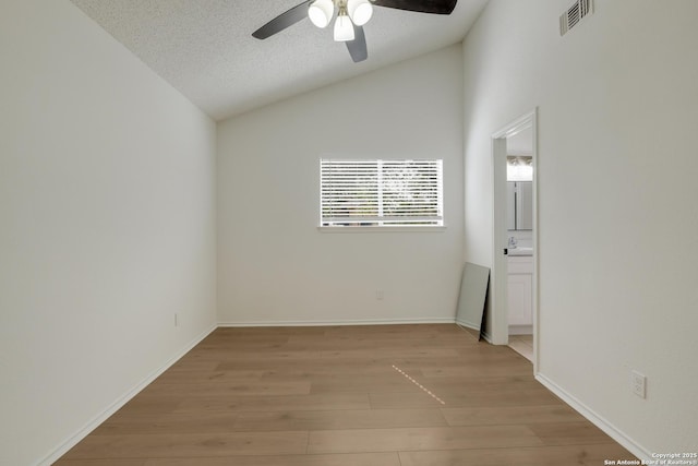 4204 Golden Spice Dr, San Antonio, TX 78222 - unfurnished room featuring lofted ceiling, light wood-style floors, a ceiling fan, and a textured ceiling
