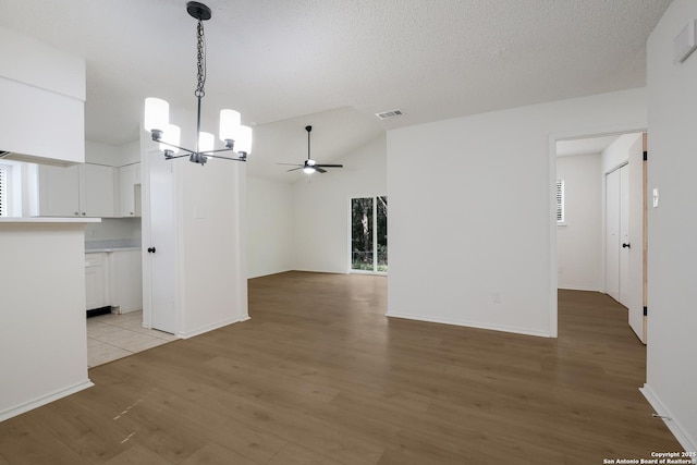 4204 Golden Spice Dr, San Antonio, TX 78222 - empty room with a chandelier, light wood-style floors, ceiling fan, and vaulted ceiling