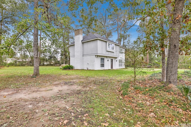 931 Republic Rd, New Caney, TX 77357 - view of home's exterior with a chimney, brick siding, board and batten siding, and a lawn