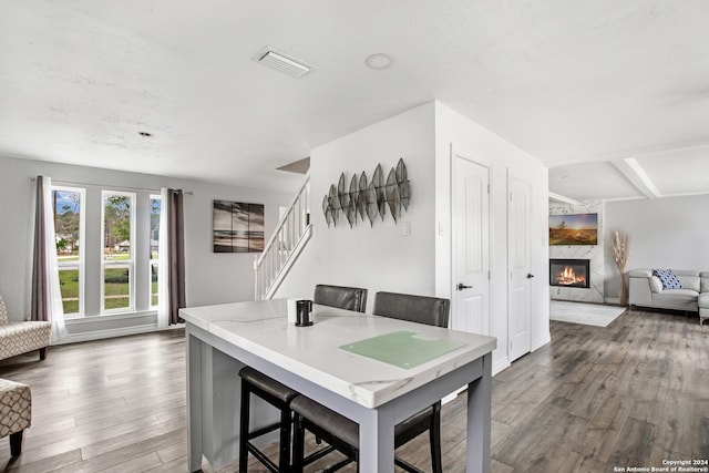 931 Republic Rd, New Caney, TX 77357 - dining room with dark wood-type flooring, a fireplace, stairs, and beamed ceiling