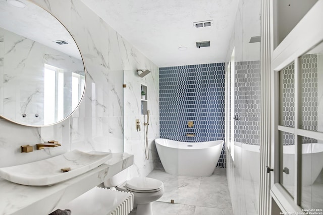 931 Republic Rd, New Caney, TX 77357 - bathroom with tile walls, a freestanding tub, marble tiled floors, and vanity