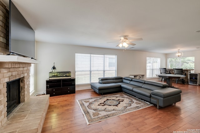 2516 Hidden Grv, Schertz, TX 78154 - living area featuring beverage cooler, a fireplace, light wood-style floors, and a ceiling fan