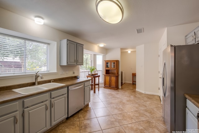 2516 Hidden Grv, Schertz, TX 78154 - kitchen with stainless steel appliances, dark countertops, gray cabinetry, and light tile patterned flooring