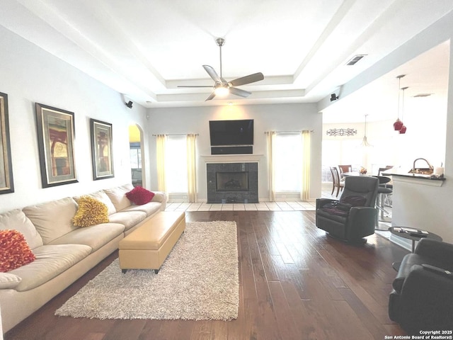 614 Slumber, San Antonio, TX 78260 - living area featuring a raised ceiling, wood-type flooring, ceiling fan, a tiled fireplace, and arched walkways