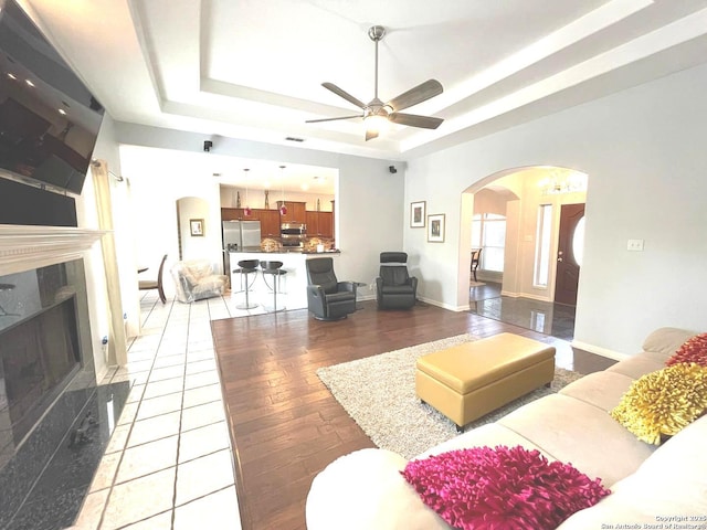614 Slumber, San Antonio, TX 78260 - living area with arched walkways, a tray ceiling, light wood-style flooring, and ceiling fan