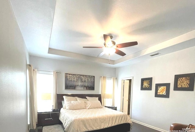 614 Slumber, San Antonio, TX 78260 - bedroom featuring a tray ceiling, multiple windows, a ceiling fan, and dark carpet