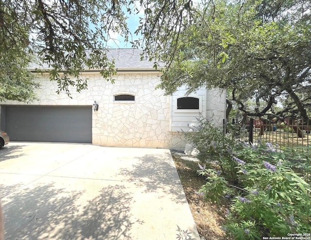 614 Slumber, San Antonio, TX 78260 - view of side of home featuring stone siding, a garage, and concrete driveway