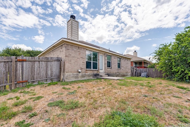 6051 Still Mdw, San Antonio, TX 78222 - rear view of property featuring a chimney, a fenced backyard, and brick siding