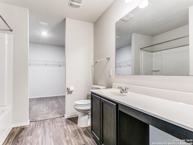 9410 Sandy Rdg, San Antonio, TX 78239 - bathroom featuring vanity, wood finished floors, a spacious closet, and bathtub / shower combination