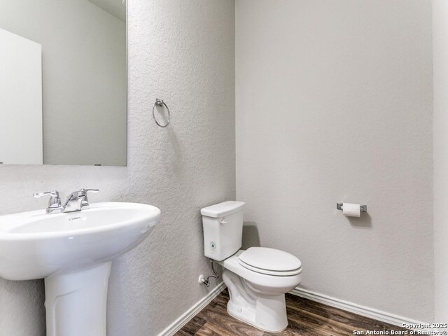 9410 Sandy Rdg, San Antonio, TX 78239 - half bathroom with wood finished floors and a textured wall