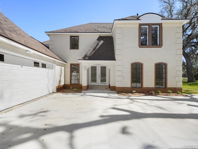 2257 River Valley Dr, West Columbia, TX 77486 - view of front of home featuring french doors, brick siding, a shingled roof, and a garage