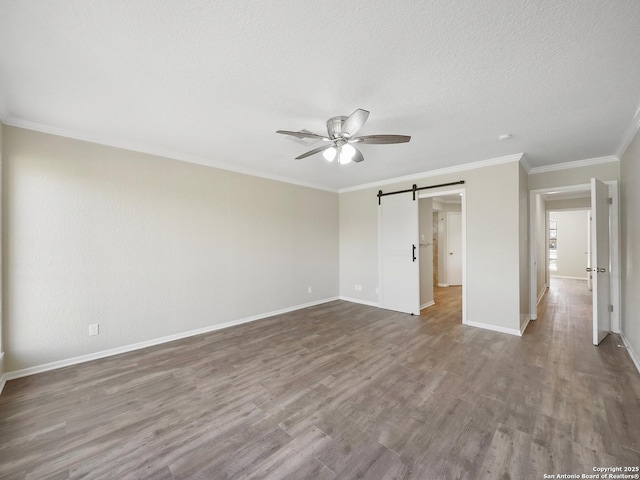 2257 River Valley Dr, West Columbia, TX 77486 - unfurnished bedroom featuring wood finished floors, a barn door, crown molding, a ceiling fan, and a textured ceiling