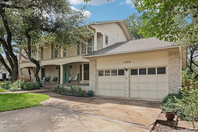 11214 Whisper Fls, San Antonio, TX 78230 - view of front of property with covered porch, a balcony, driveway, a garage, and brick siding