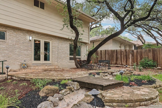 11214 Whisper Fls, San Antonio, TX 78230 - back of house featuring french doors, brick siding, a patio area, and a wooden deck