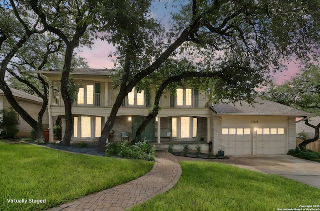 11214 Whisper Fls, San Antonio, TX 78230 - view of front of house featuring driveway, a lawn, an attached garage, and brick siding