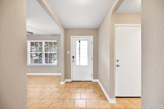 14055 Cremello Fls, San Antonio, TX 78254 - foyer entrance featuring a textured wall, arched walkways, and light tile patterned floors
