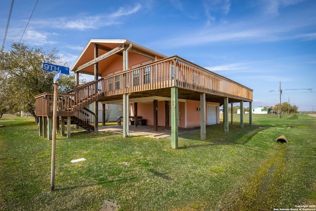 902 Harrison Prt, Oconnor, TX 77982 - back of property featuring a deck, a lawn, a garage, and a patio
