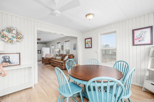 902 Harrison Prt, Oconnor, TX 77982 - dining space featuring a ceiling fan, light wood finished floors, healthy amount of natural light, and wooden walls