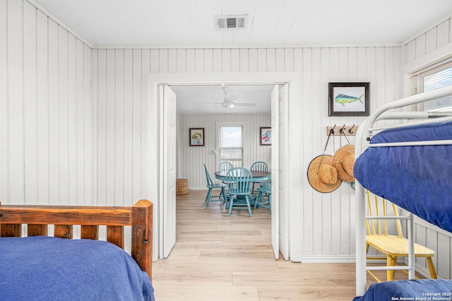 902 Harrison Prt, Oconnor, TX 77982 - bedroom featuring light wood-style floors, wood walls, and multiple windows
