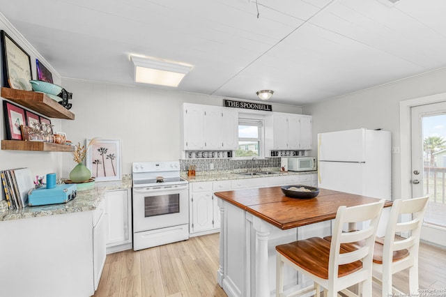 902 Harrison Prt, Oconnor, TX 77982 - kitchen featuring white appliances, white cabinetry, and healthy amount of natural light