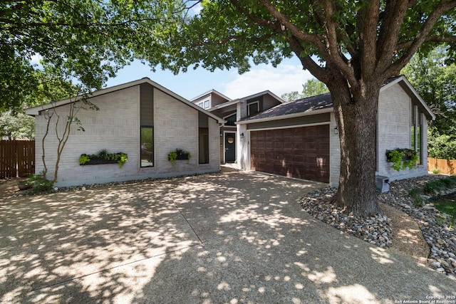 2102 Encino Clf, San Antonio, TX 78259 - mid-century home featuring an attached garage, brick siding, and concrete driveway