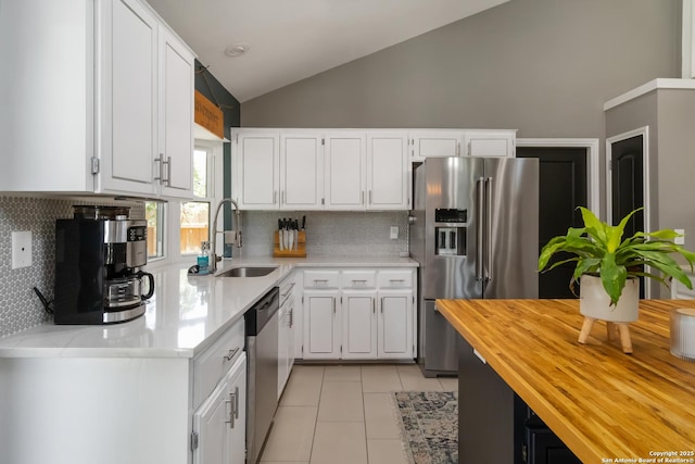 2102 Encino Clf, San Antonio, TX 78259 - kitchen with stainless steel appliances, wood counters, lofted ceiling, light tile patterned floors, and white cabinets