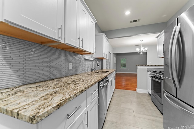 1806 W Mistletoe Ave, San Antonio, TX 78201 - kitchen featuring stainless steel appliances, a chandelier, light stone counters, backsplash, and recessed lighting