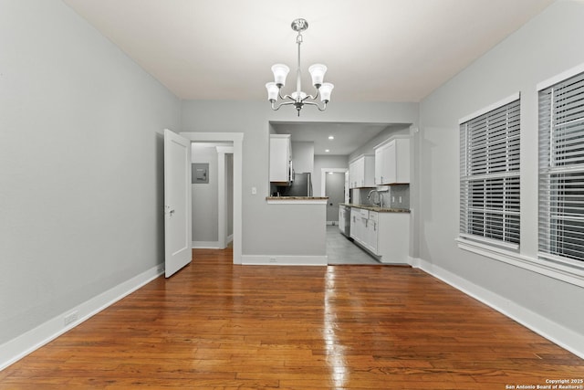 1806 W Mistletoe Ave, San Antonio, TX 78201 - kitchen with a chandelier, stainless steel dishwasher, white cabinets, wood finished floors, and freestanding refrigerator