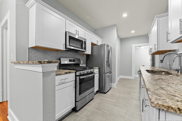 1806 W Mistletoe Ave, San Antonio, TX 78201 - kitchen with stainless steel appliances, backsplash, white cabinets, stone counters, and recessed lighting