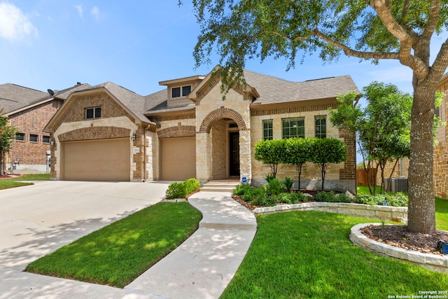 25926 Natal Plum, San Antonio, TX 78261 - french country inspired facade featuring stone siding, a front yard, driveway, brick siding, and a garage