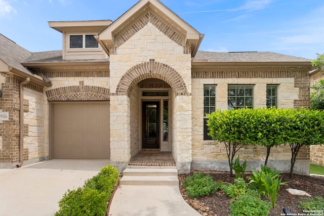 25926 Natal Plum, San Antonio, TX 78261 - entrance to property with driveway, stone siding, a garage, and a shingled roof