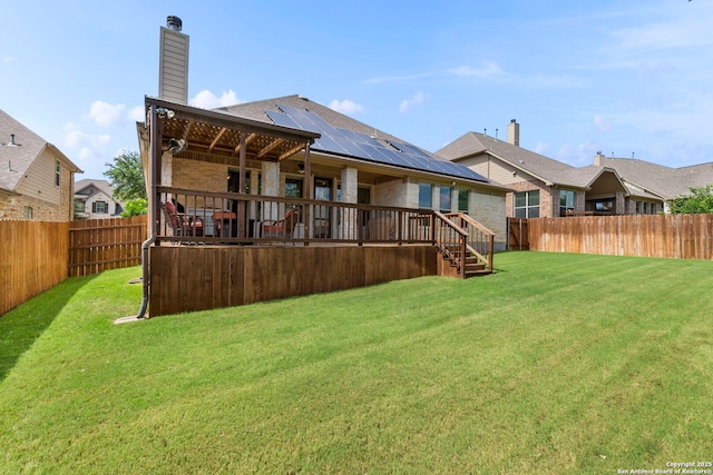 25926 Natal Plum, San Antonio, TX 78261 - back of house featuring a fenced backyard, a chimney, solar panels, and stone siding