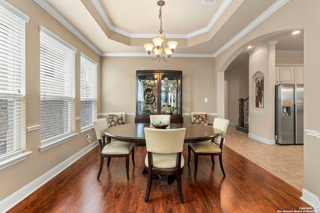 25926 Natal Plum, San Antonio, TX 78261 - dining space with arched walkways, a chandelier, a raised ceiling, dark wood finished floors, and crown molding