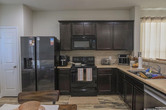 11334 Pink Star, San Antonio, TX 78245 - kitchen featuring black appliances, light countertops, light wood-type flooring, and decorative backsplash