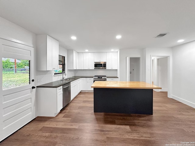543 Cosgrove, San Antonio, TX 78210 - kitchen with appliances with stainless steel finishes, wooden counters, decorative backsplash, a kitchen island, and recessed lighting