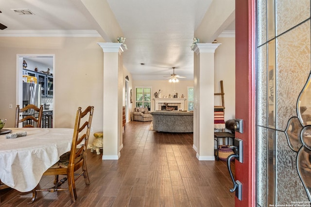 8526 Spartan Ter, Universal City, TX 78148 - dining room featuring ceiling fan, ornate columns, dark wood-style floors, a fireplace, and ornamental molding