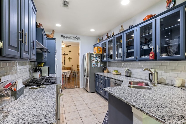 8526 Spartan Ter, Universal City, TX 78148 - kitchen featuring stainless steel appliances, blue cabinetry, decorative backsplash, light stone countertops, and recessed lighting