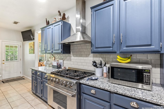 8526 Spartan Ter, Universal City, TX 78148 - kitchen with stainless steel appliances, wall chimney exhaust hood, blue cabinetry, and decorative backsplash