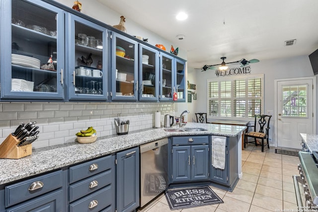 8526 Spartan Ter, Universal City, TX 78148 - kitchen with appliances with stainless steel finishes, blue cabinetry, ceiling fan, backsplash, and light tile patterned flooring
